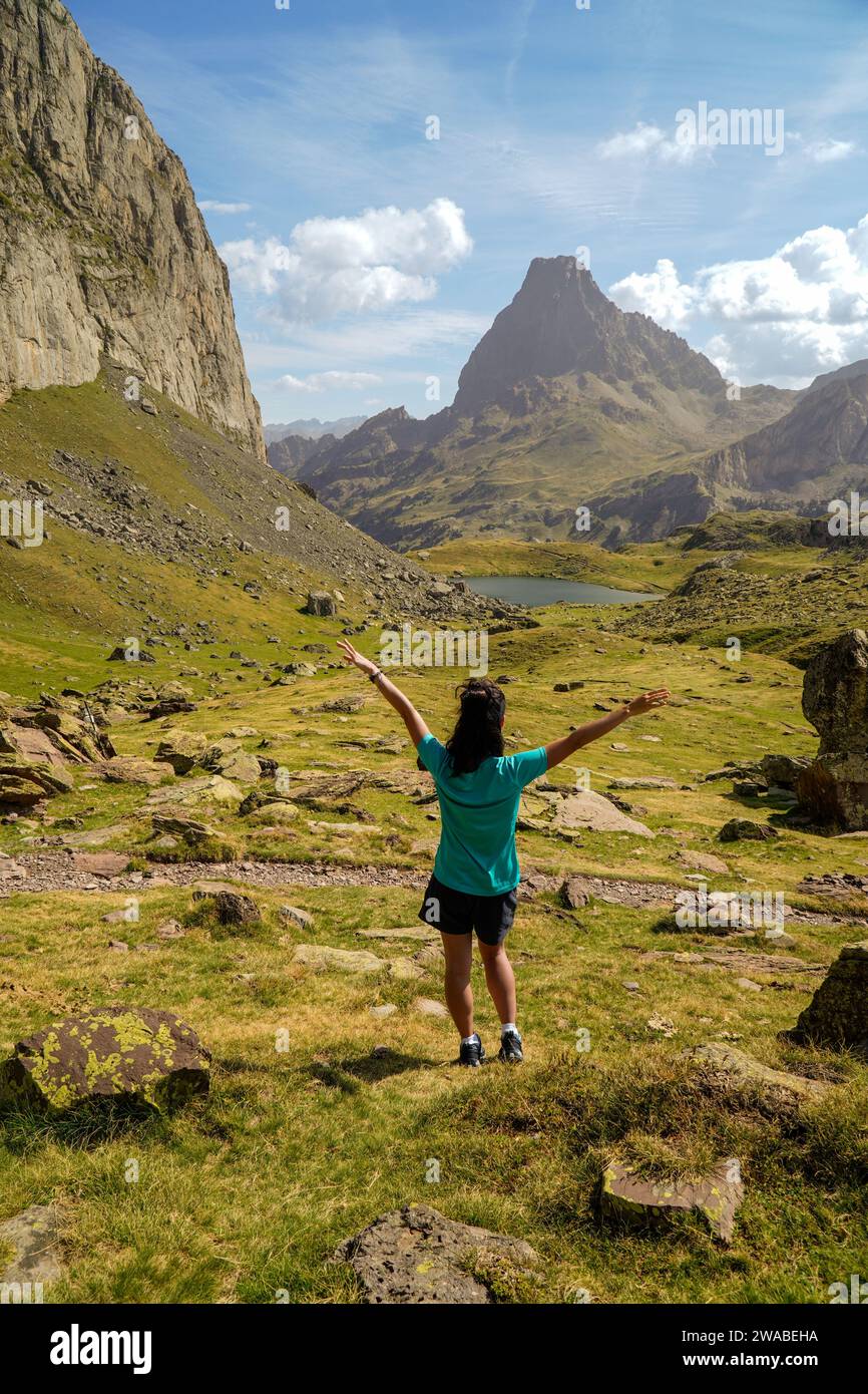 Photo verticale vue arrière d'une jeune femme sportive levant les bras dans la montagne Banque D'Images