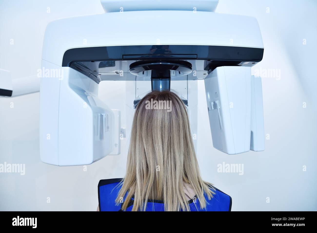 Vue arrière du patient de femme faire une image de rayon X sur le tomographe panoramique dentaire dans la clinique. Dentisterie et concept de soins de santé. Banque D'Images
