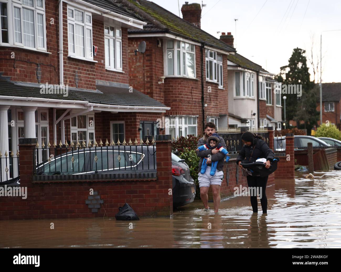 Loughborough, Leicestershire, Royaume-Uni. 3 janvier 2024. Météo britannique. Une famille quitte sa maison inondée sur Belton Road. De fortes pluies ont frappé une grande partie du Royaume-Uni alors que le petit mais puissant Storm Henk a frappé. Crédit Darren Staples/Alamy Live News. Banque D'Images