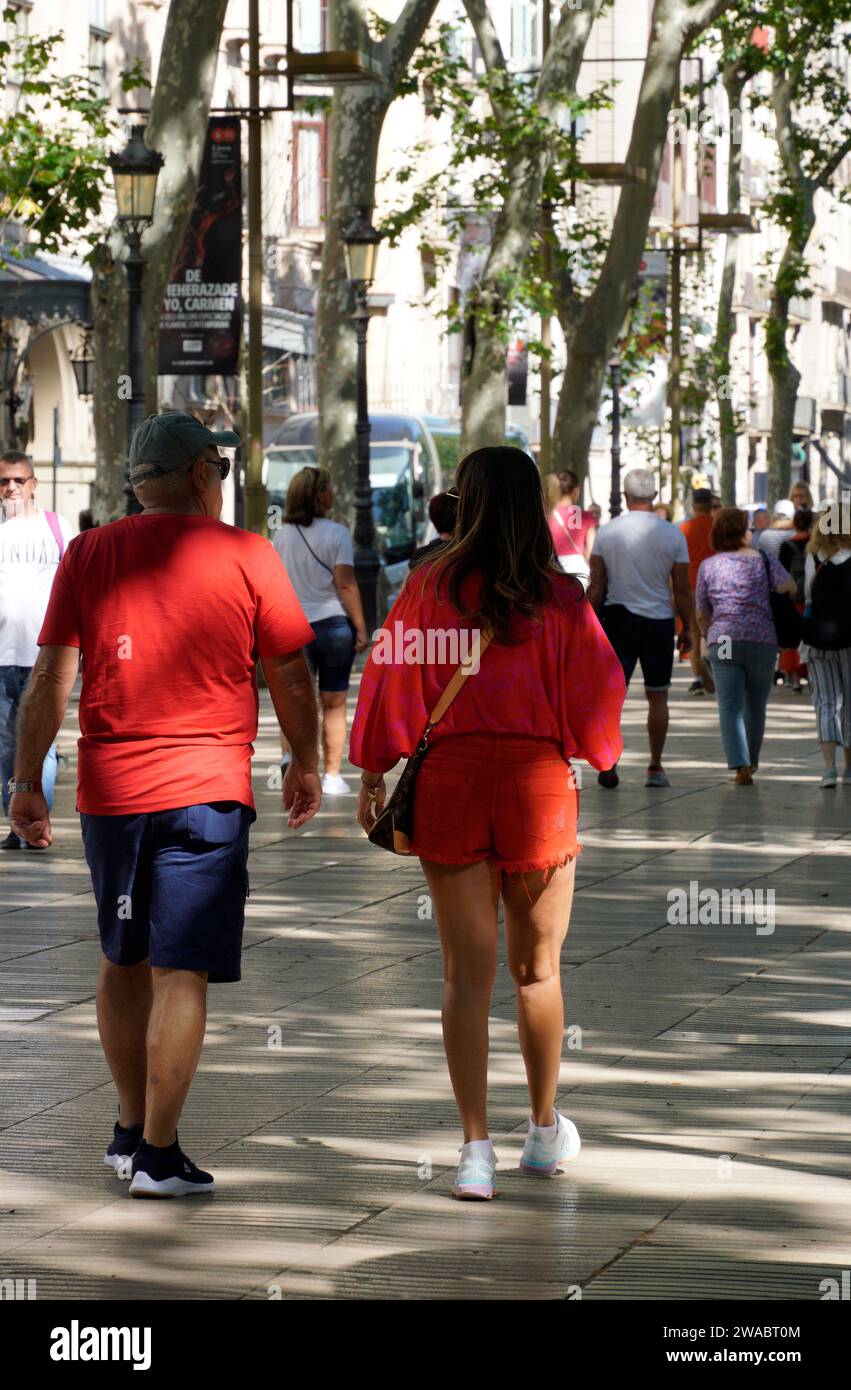 Barcelone, Espagne - 26 mai 2022 : couple vêtu de promenades rouges le long de la Rambla dans le centre de la ville de Barcelone. Banque D'Images