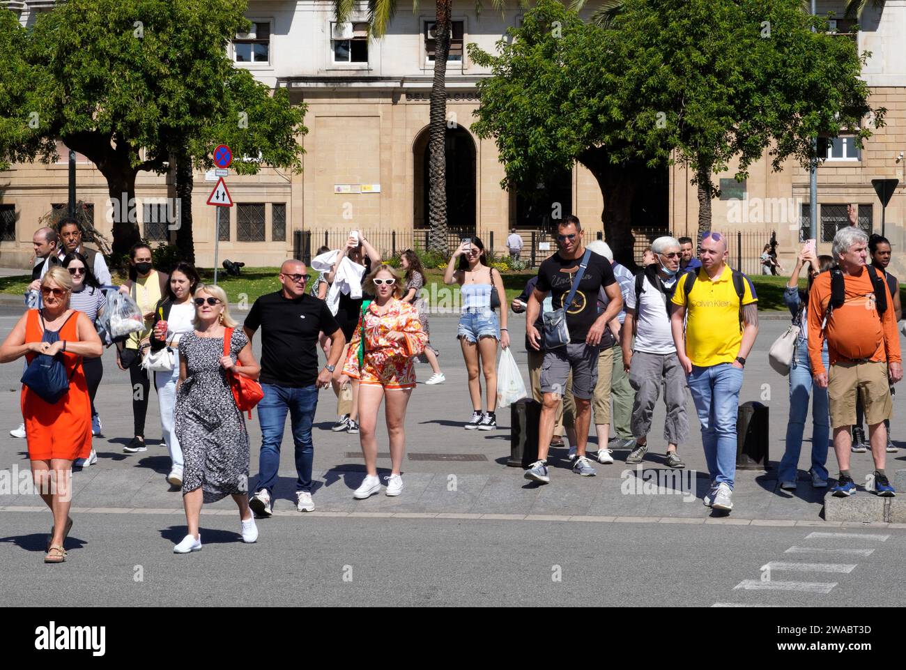 Barcelone, Espagne - 26 mai 2022 : les personnes en plein soleil commencent à traverser le passage piétonnier sur une avenue animée du centre-ville Banque D'Images