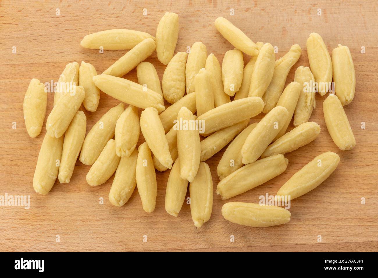 Ravioles de Melle gnocchis typiques de Val Varaita, Piémont, Italie à base de pommes de terre, farine et fromage. Gnocchi brut sur une planche à découper en bois Banque D'Images