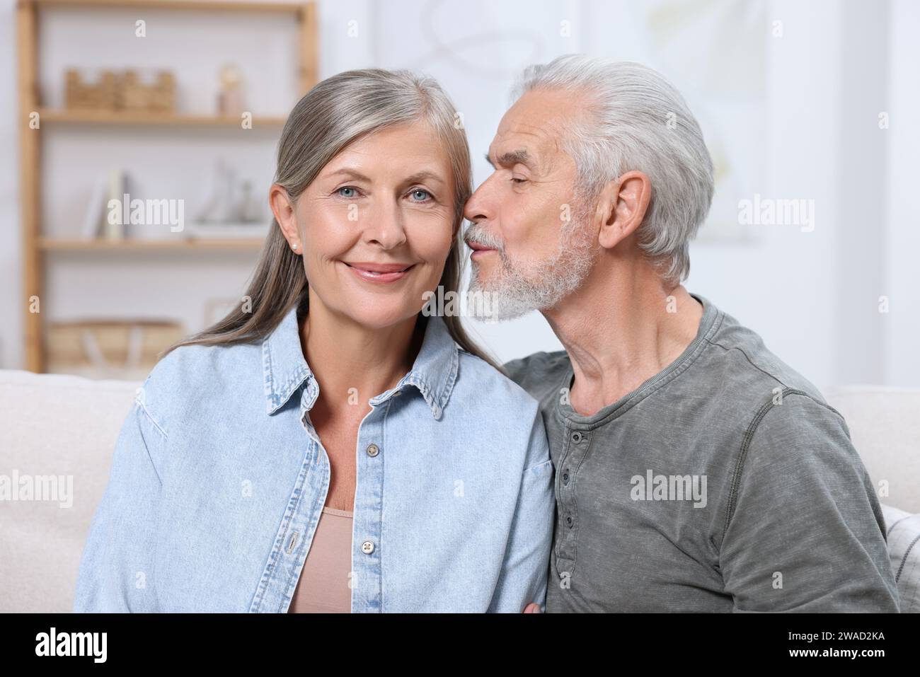 Homme senior embrassant sa femme bien-aimée à l'intérieur Banque D'Images