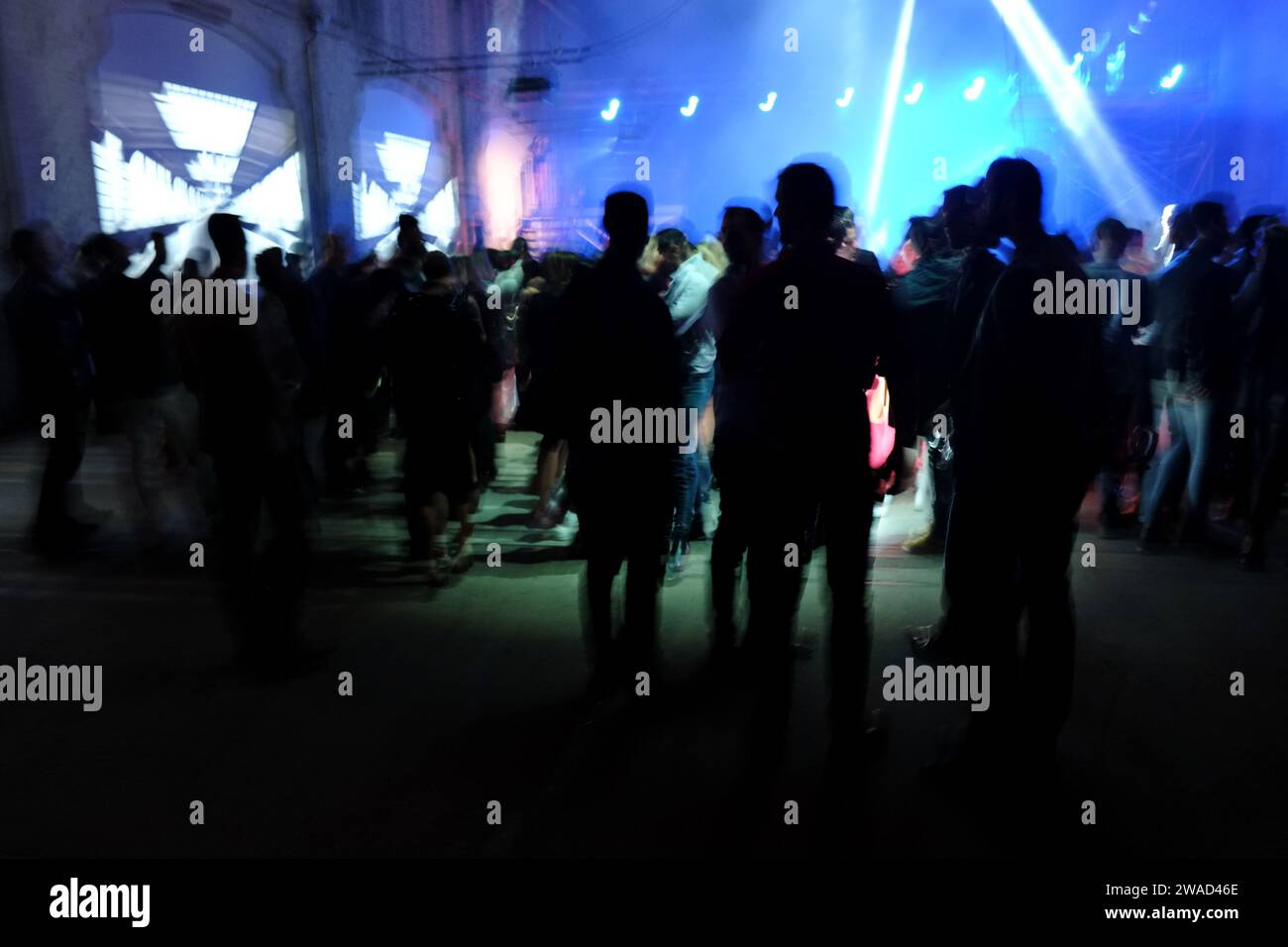 Silhouettes de personnes contre éclairage et projections de soirées dansantes lumineuses et colorées dans un immense entrepôt, fêtes et vie nocturne à Sydney, Australie Banque D'Images