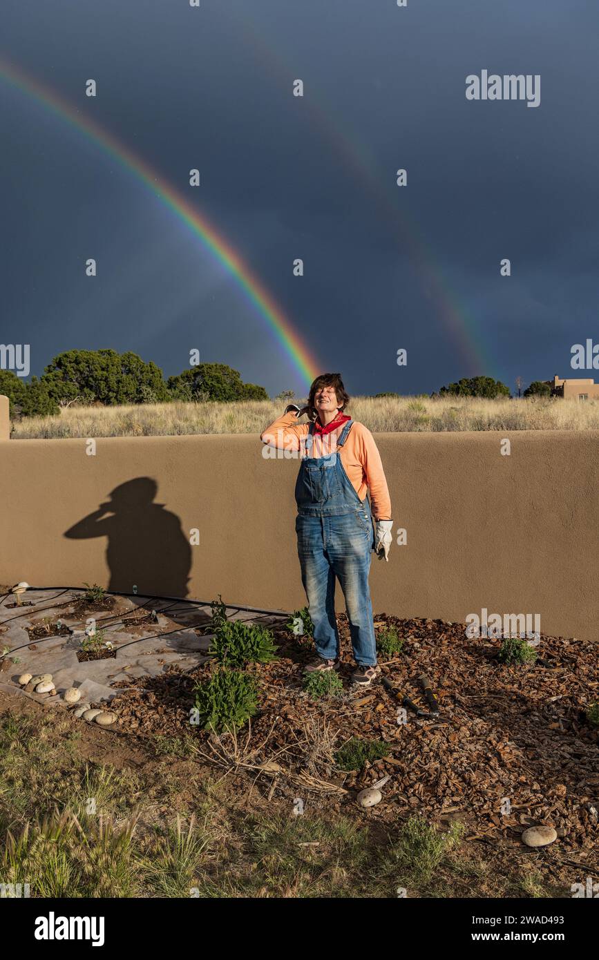USA, Nouveau Mexique, Santa Fe, Portrait de femme dans le jardin avec double arc-en-ciel en arrière-plan Banque D'Images