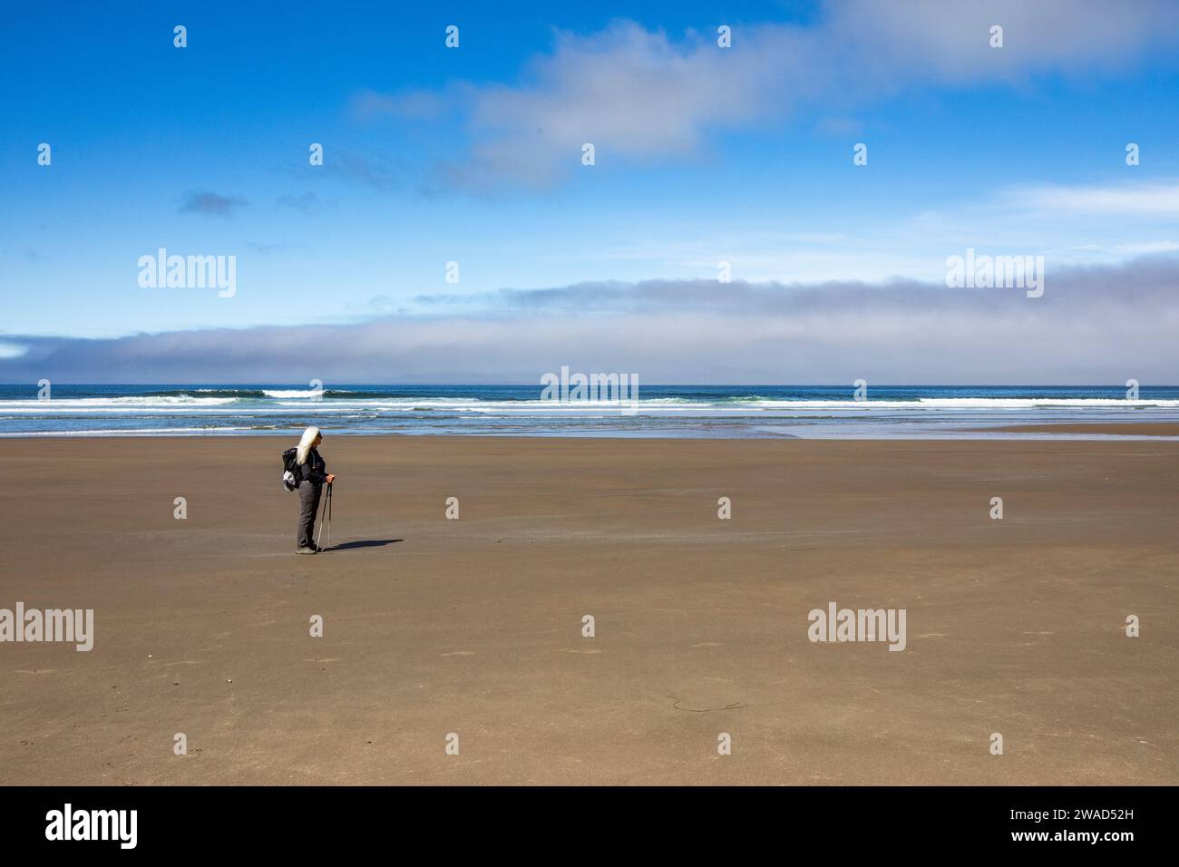 Femme debout sur la plage de sable et regardant la vue Banque D'Images