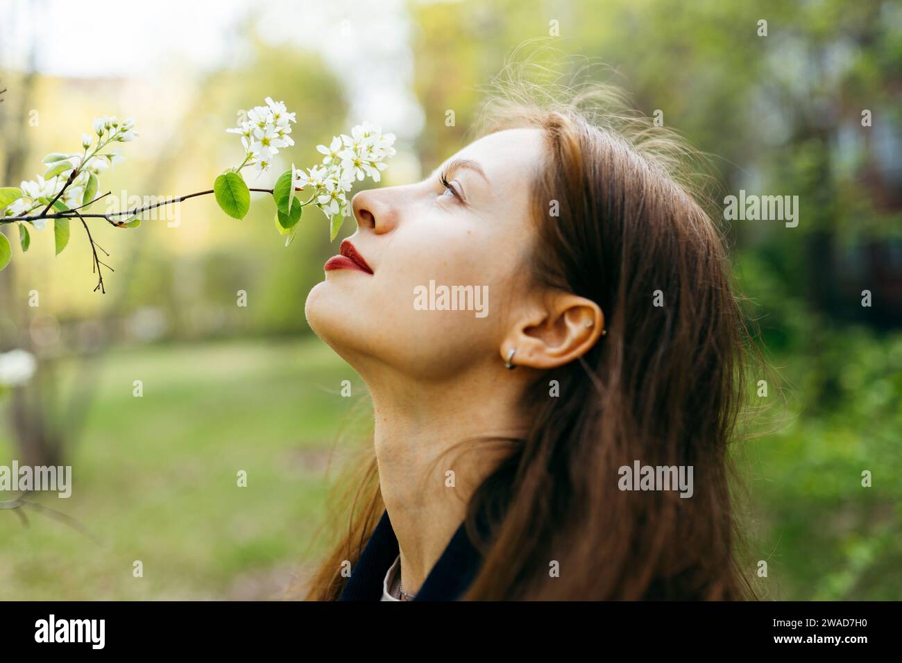 Belle femme sentant la fleur dans le verger Banque D'Images