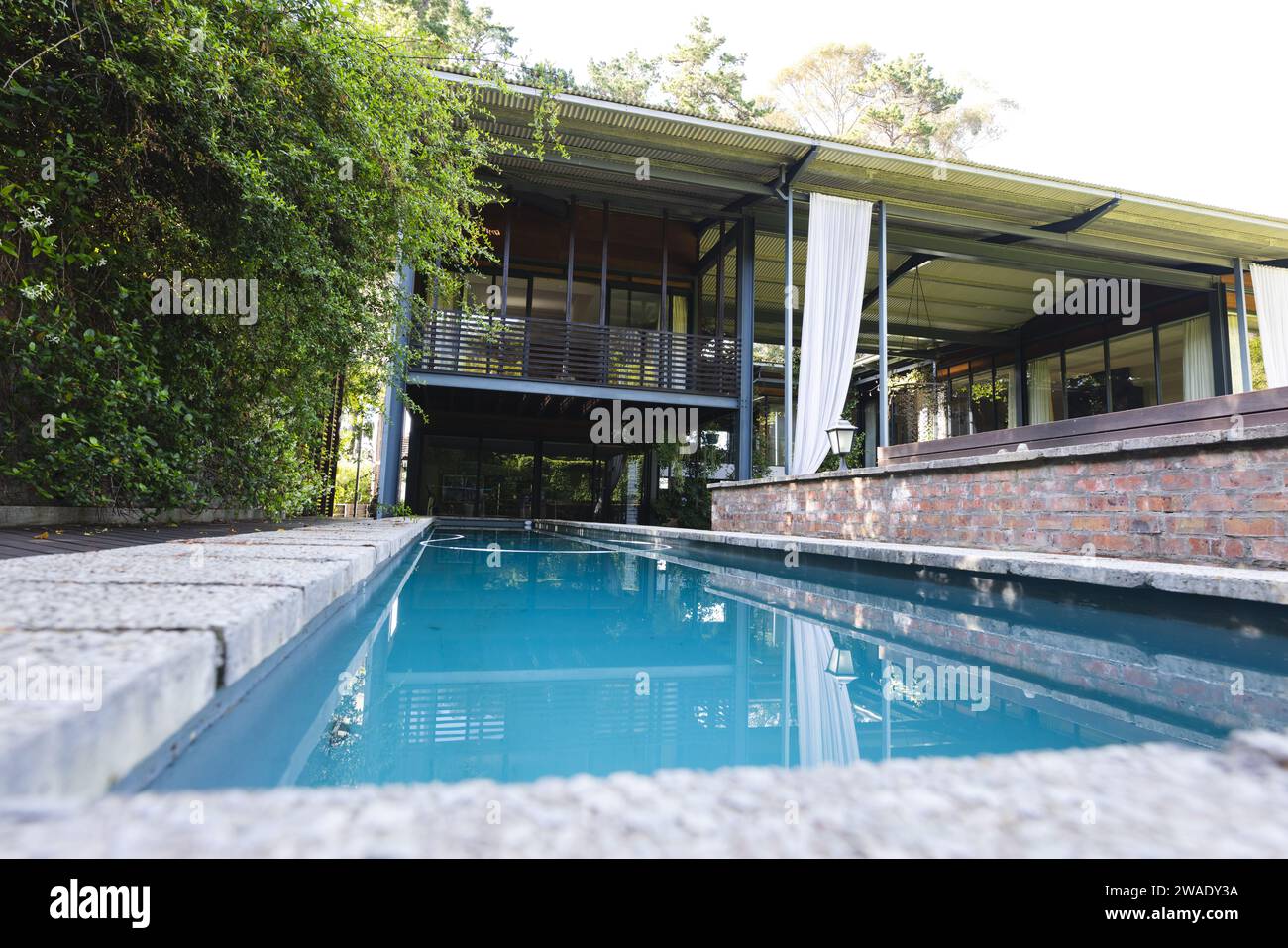 Moderne grande maison vide avec balcon et piscine dans un grand jardin vert. Architecture, nature et design. Banque D'Images Moderne grande maison vide avec balcon et piscine dans un grand jardin vert. Architecture, nature et design. Banque D'Images