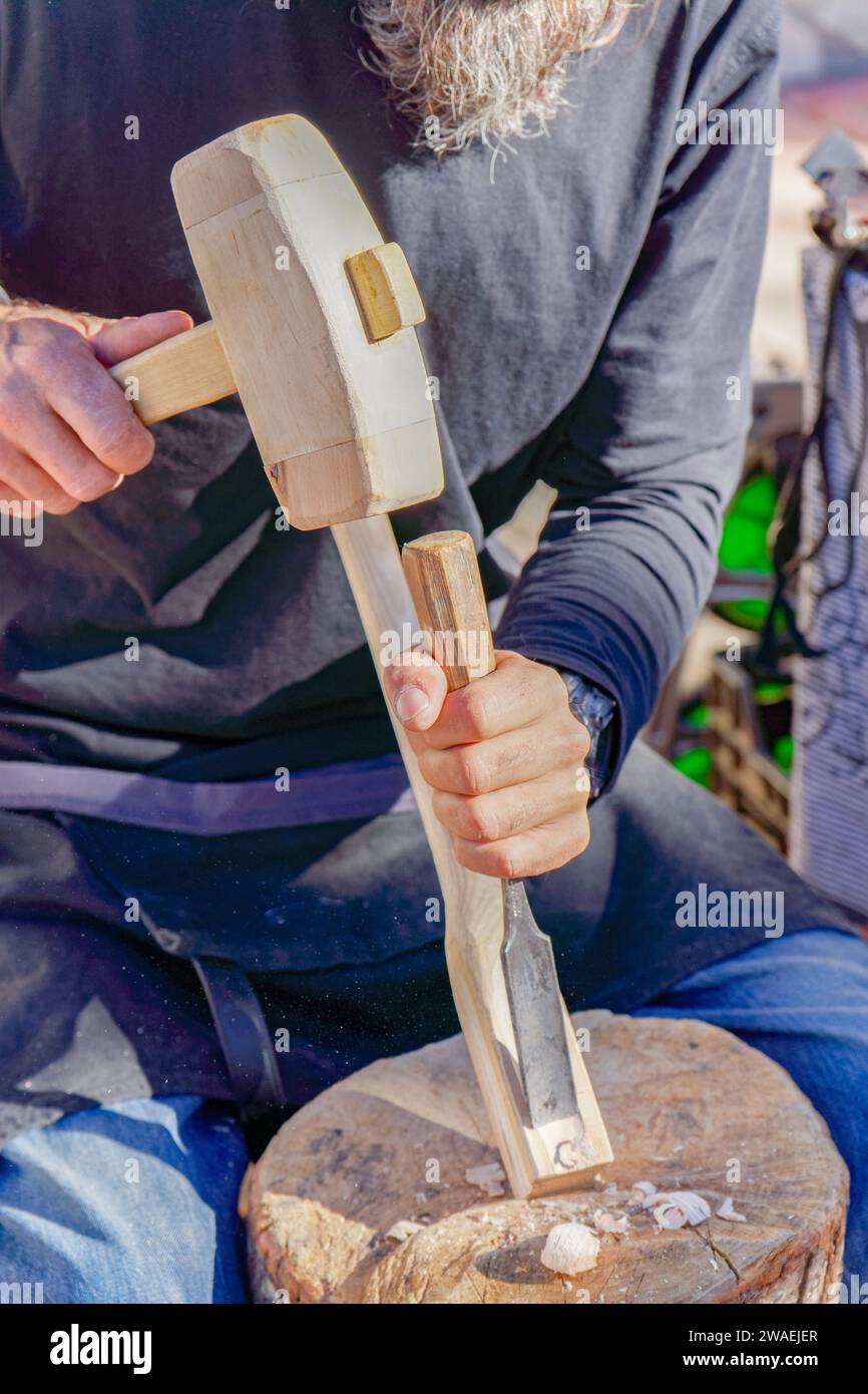 artisan travaillant avec du bois sur un marché de rue à son stand d'articles en bois faits à la main Banque D'Images