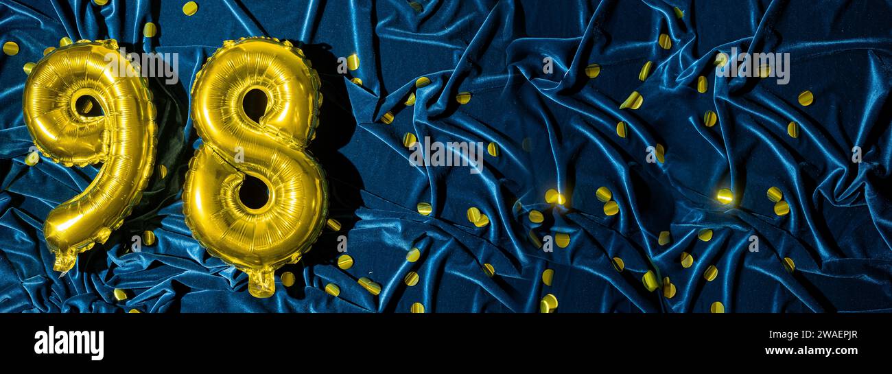 ballon en feuille d'or numéro quatre-vingt-dix-huit. Carte d'anniversaire ou d'anniversaire avec l'inscription 98. fond de velours bleu. Célébration d'anniversaire. Bannière. Banque D'Images