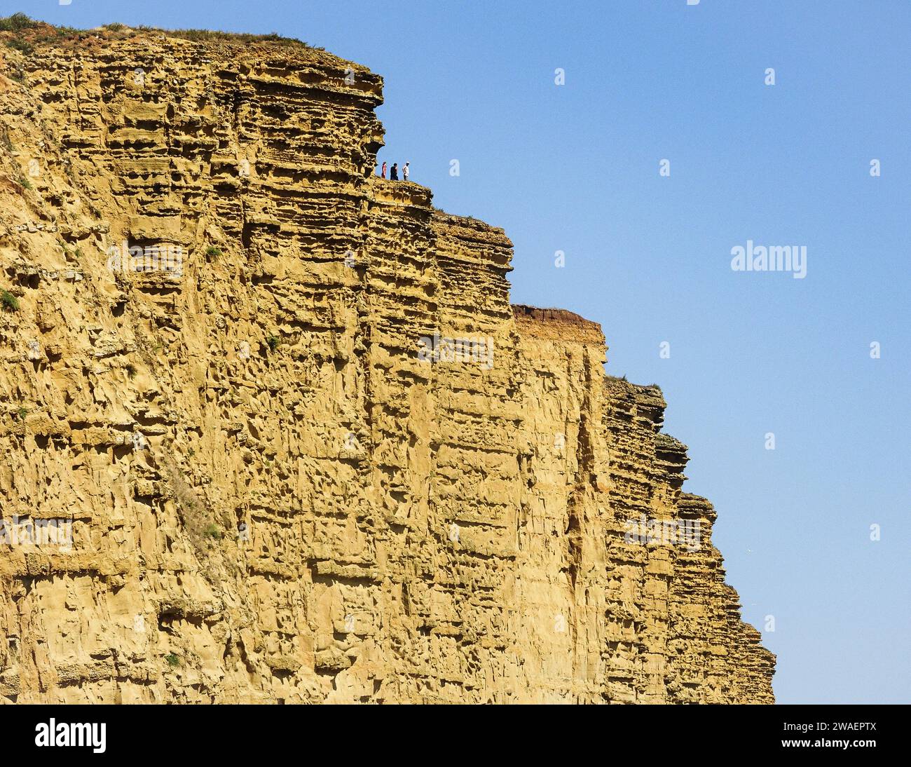 Un groupe de personnes diverses se dresse au sommet d'une majestueuse falaise rocheuse profitant de la vue sur l'horizon magnifique Banque D'Images