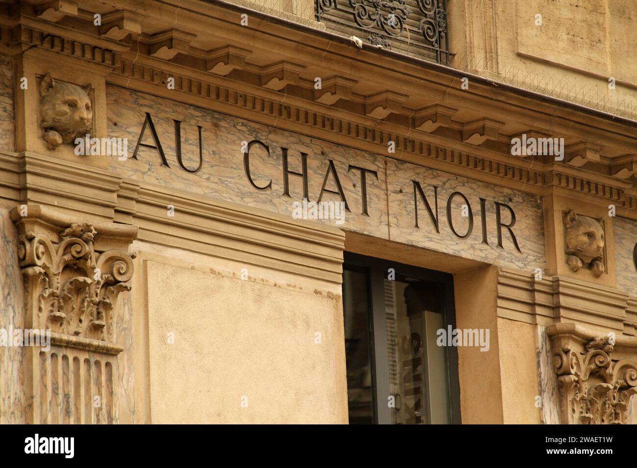 Un panneau vintage au-dessus d'une fenêtre en France, avec les mots 'au Chat Noir' imprimés sur itc Banque D'Images
