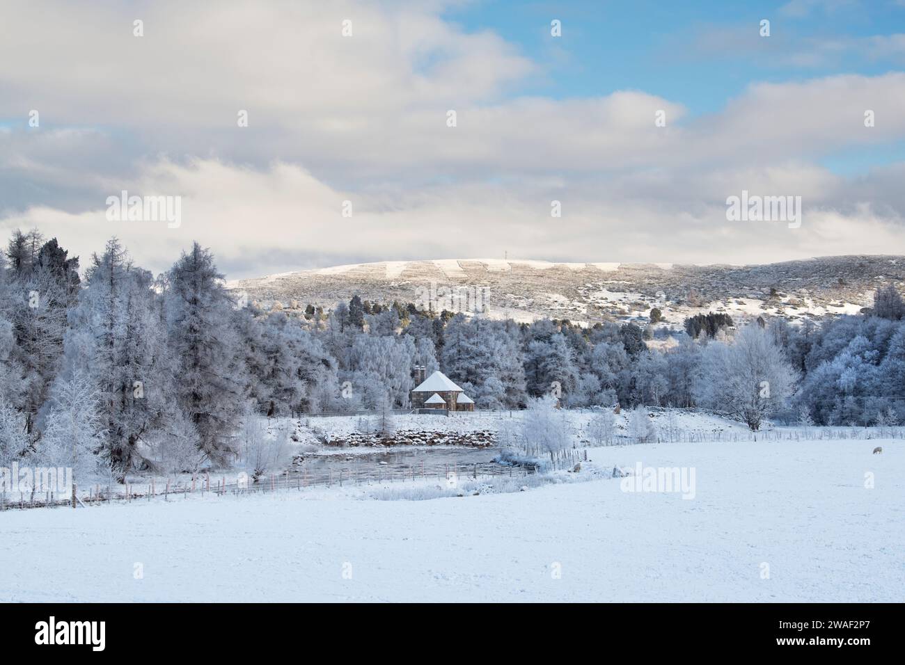 Cottage écossais au bord de la rivière Gairn dans la neige. Gairnshiel, Cairngorms, Highlands, Écosse Banque D'Images