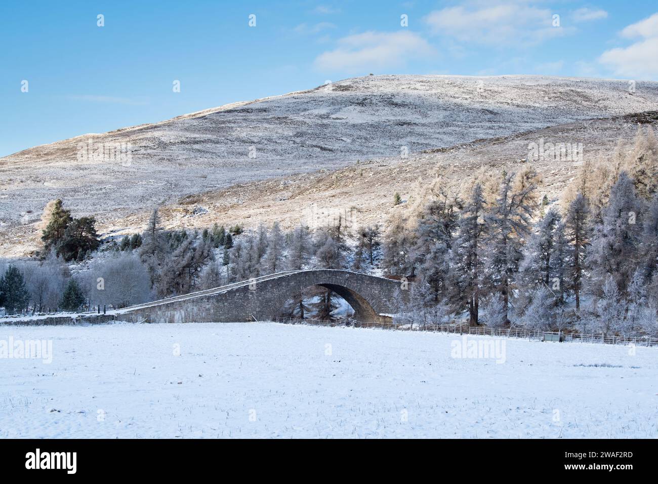 Pont de pierre sur la rivière Gairn dans la neige. Gairnshiel, Cairngorms, Highlands, Écosse Banque D'Images