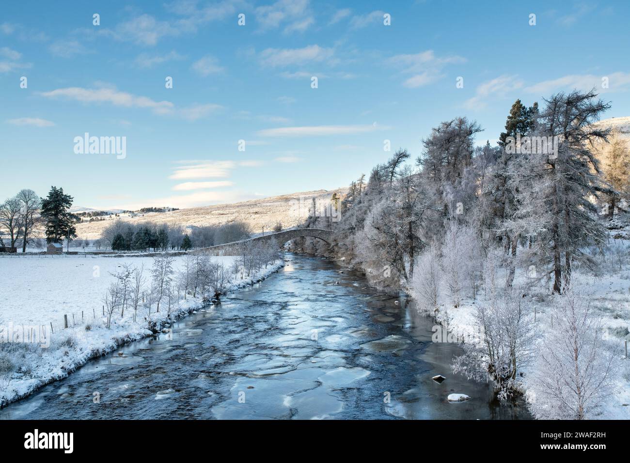 Pont de pierre sur la rivière Gairn dans la neige. Gairnshiel, Cairngorms, Highlands, Écosse Banque D'Images
