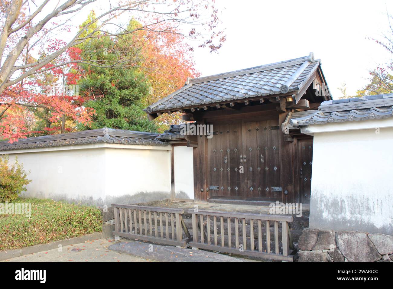Portail en bois et feuilles d'automne au jardin de Koko-en tôt le matin, Himeji, Japon Banque D'Images