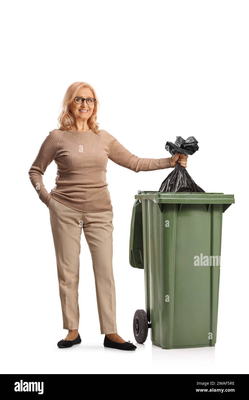 Femme jetant un sac à déchets en plastique dans une poubelle isolée sur fond blanc Banque D'Images