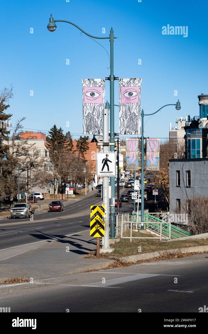 Calgary Alberta Canada, décembre 22 2023 : vue de rue d'un drapeau artistique sur un lampadaire moderne à un passage en regardant vers le bas d'une route avec la circulation. Banque D'Images