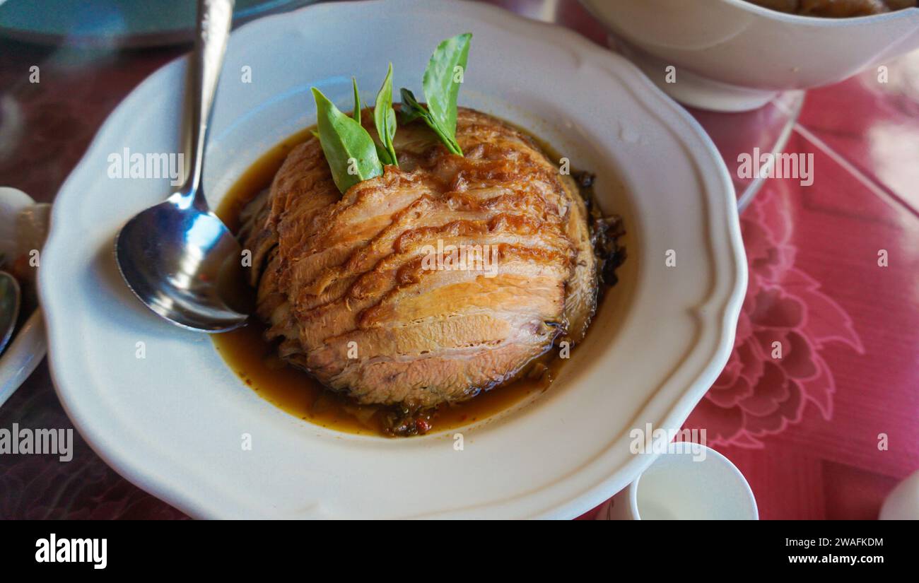 Jarret de porc à feuilles de thé du Yunnan. Jarret de porc traditionnel thaïlandais. Cuisse de porc mijotée sur riz cuit. Célèbre cuisine de rue en Thaïlande Banque D'Images