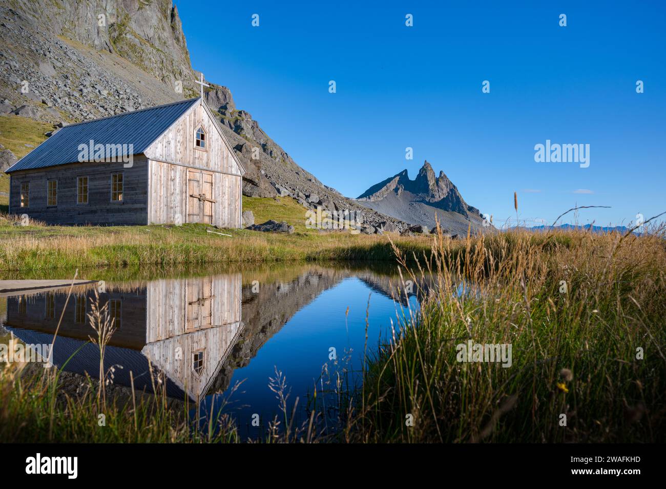 Seule et petite chapelle en bois construite au bas de la montagne Vestrahorn par une journée ensoleillée d'été, Islande Banque D'Images