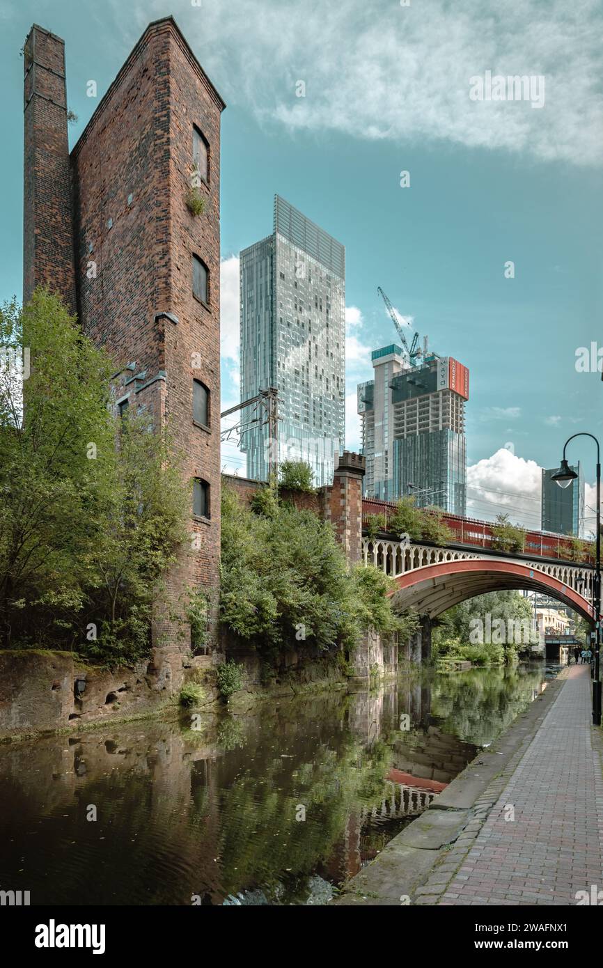 Charme vintage et horizon urbain, pont victorien et patrimoine industriel contrastent avec les gratte-ciel modernes le long du canal Rochdale. Banque D'Images