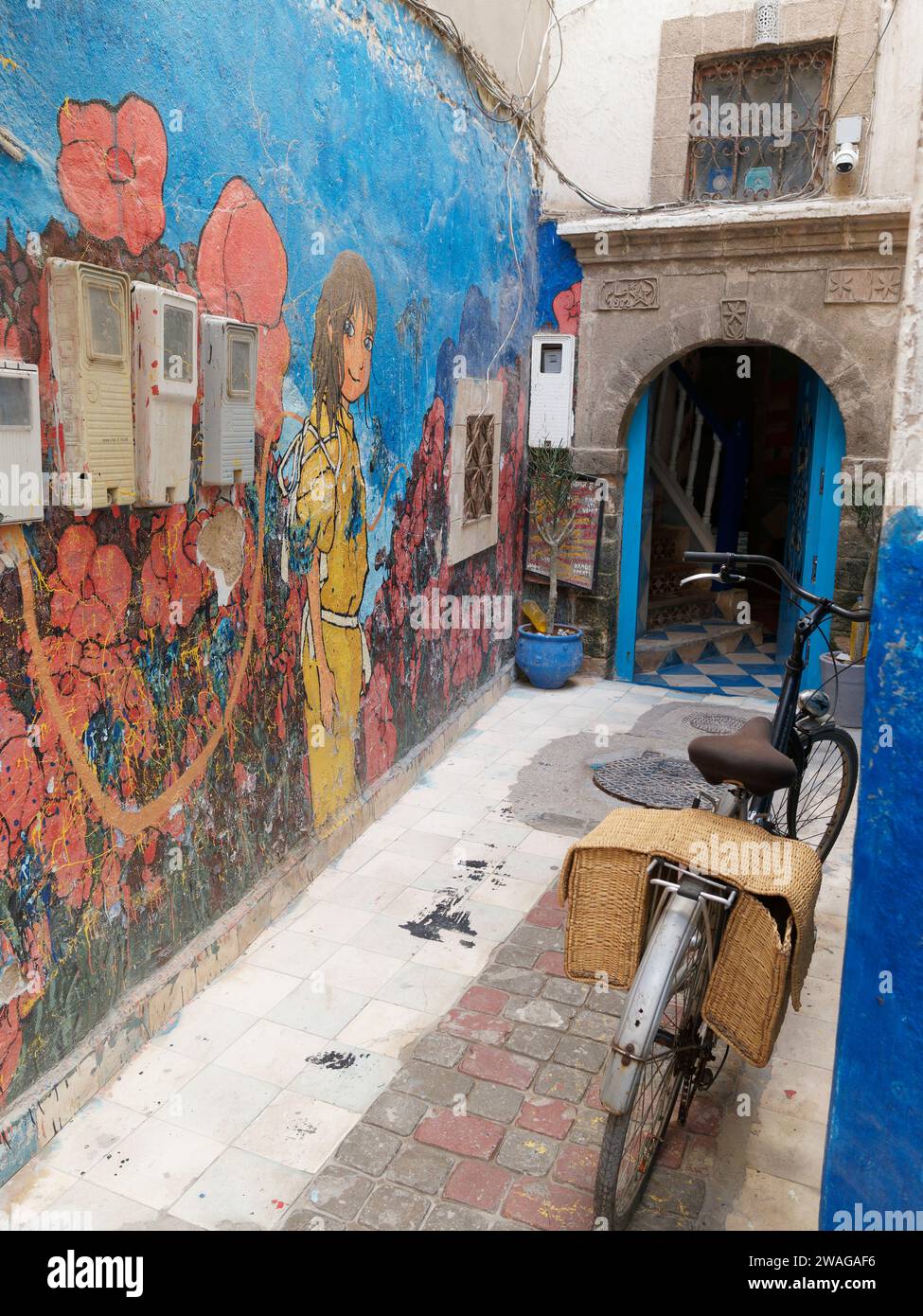 Œuvre d'art colorée sur un mur à côté d'une porte dans une rue étroite de la ville d'Essaouira, Maroc. 4 janvier 2024 Banque D'Images