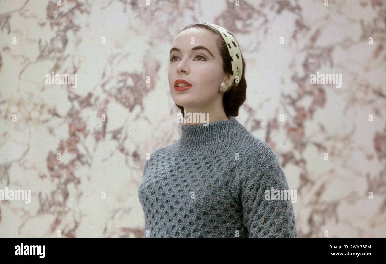 Années 1950, historique, une jeune femme élégante modelant la dernière laine tricotée manches longues, haut col ajusté, Angleterre, Royaume-Uni. Dans les années 1940 et 50, la laine était populaire comme tissu pour femmes car elle était élégante, féminine et classique. Banque D'Images