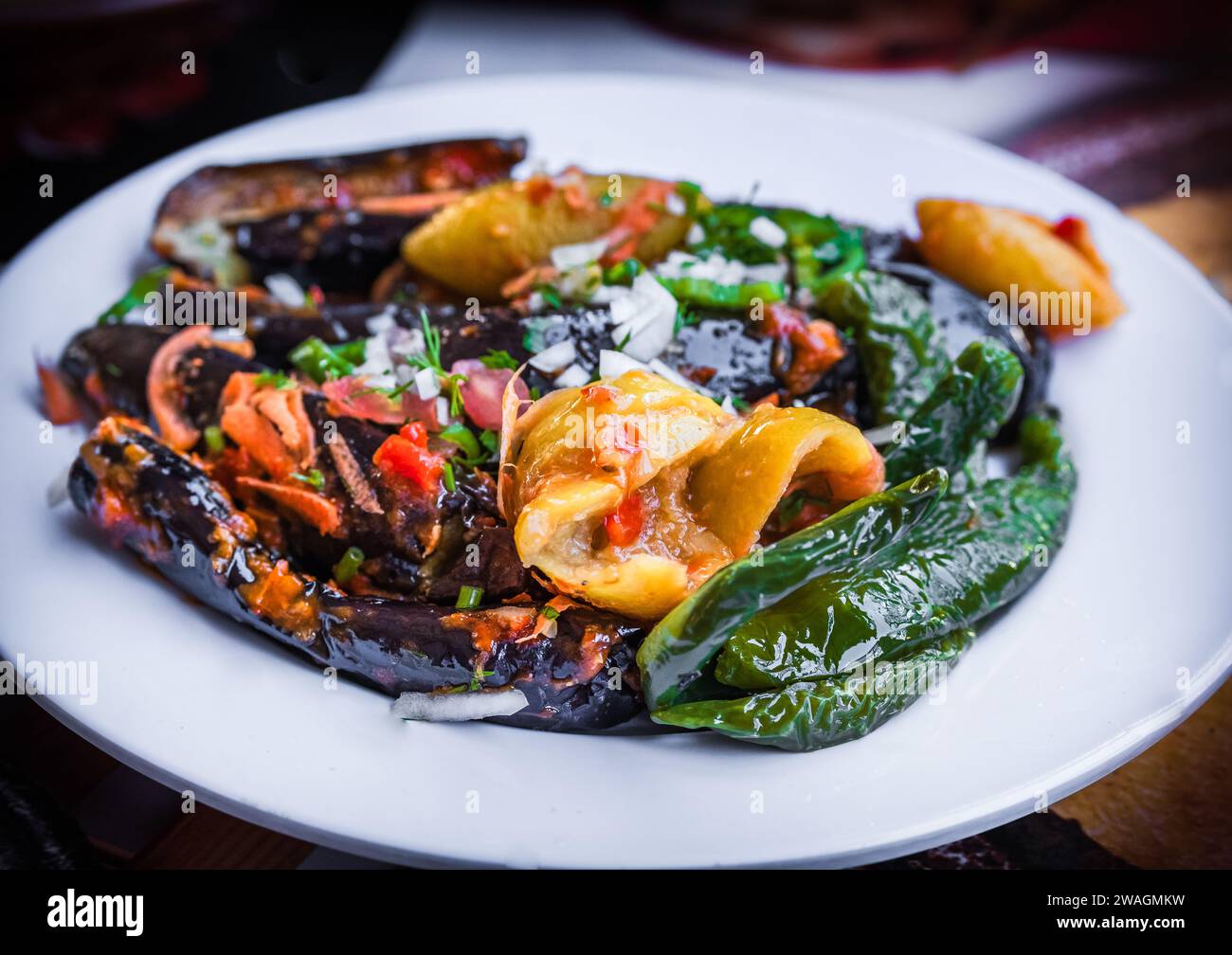 Aubergine rôtie marinée et poivrons verts farcis à l'ail, piment rouge, vinaigre, citron, coriandre, persil, tomates et épices hachées, Banque D'Images