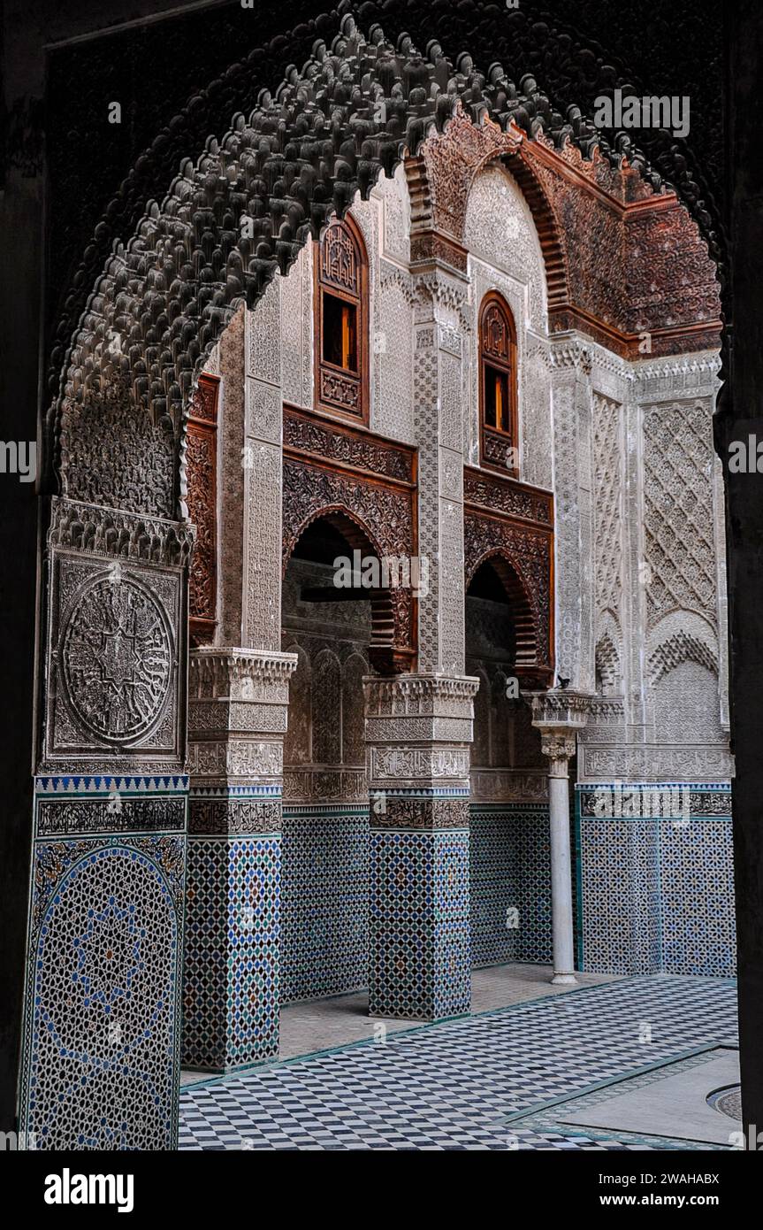 Al-Attarine Madrasa, une école religieuse construite au 14e siècle à Fès, Maroc. Vue sur la cour sous une arche avec stuc mauresque complexe Banque D'Images