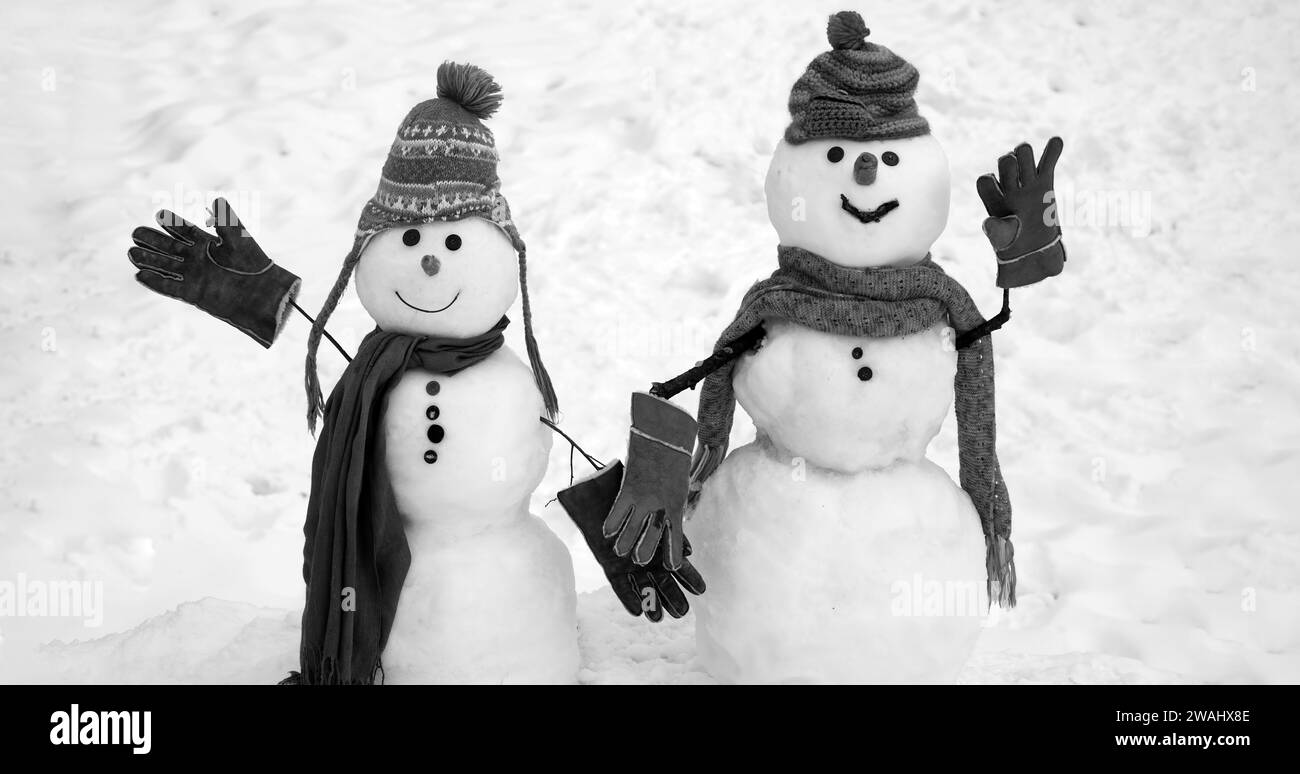 Bonhomme de neige en chapeau et foulard sur terrain enneigé. Carte de vœux Joyeux Noël et joyeux nouvel an avec espace copie. Banque D'Images