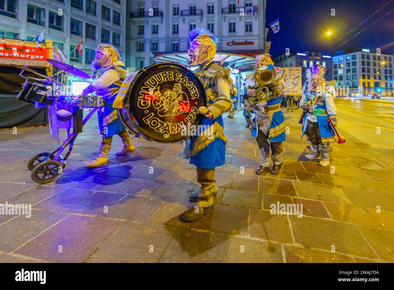 Lucerne, Suisse - 20 février 2023: Groupe de musiciens en costumes marche dans les rues, dans le cadre d'une parade tôt le matin du Carnaval de Fasnacht Banque D'Images