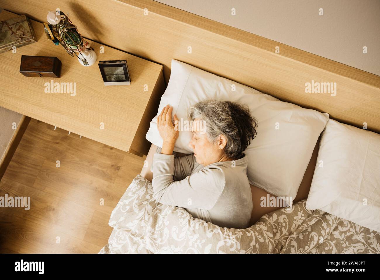Dormant femme âgée dans son lit tôt le matin. Banque D'Images