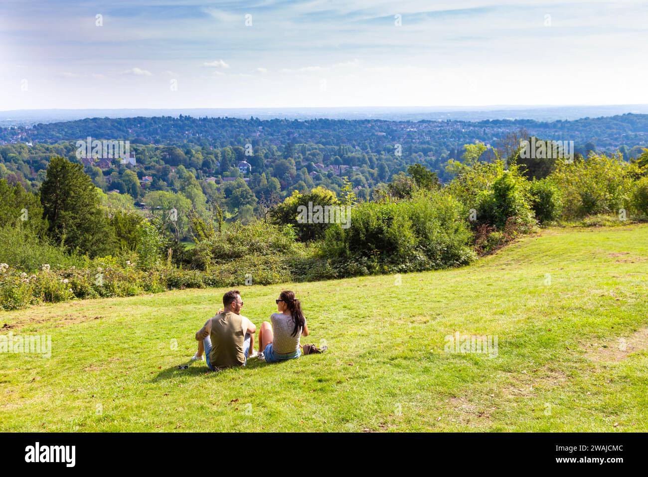 Des gens assis sur l'herbe à Reigate Hill Viewpoint, North Downs Way, Surrey, Angleterre Banque D'Images