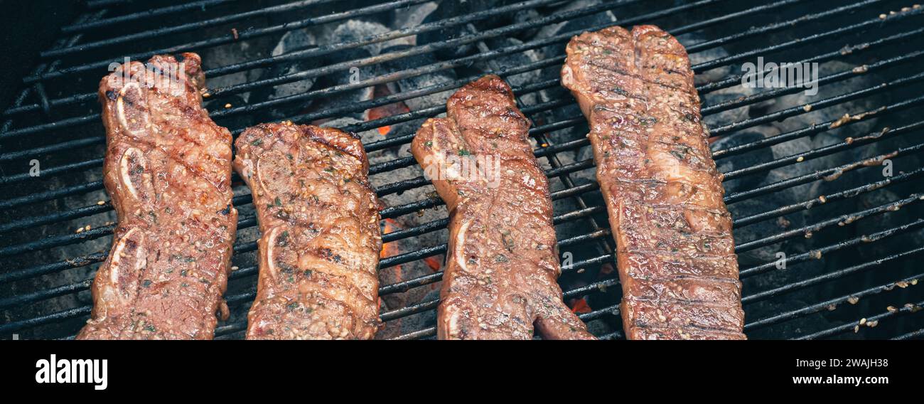 Les morceaux de bœuf grésillent sur un gril au charbon traditionnel, créant un arôme délicieux Banque D'Images