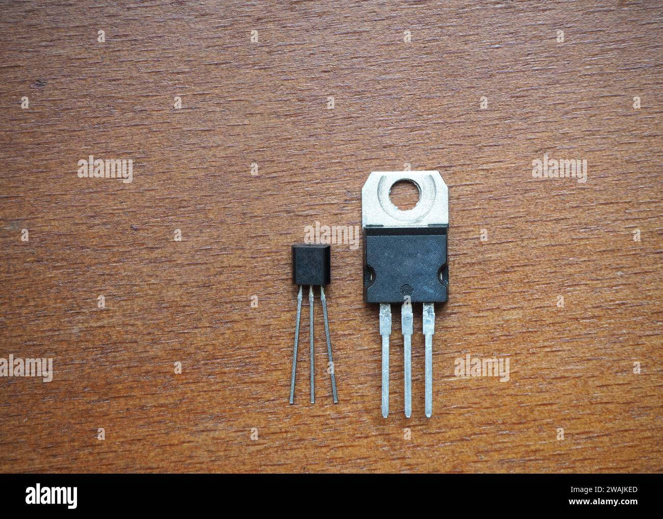 Composants semi-conducteurs sur fond en bois. transistors dans deux cas différents. Banque D'Images
