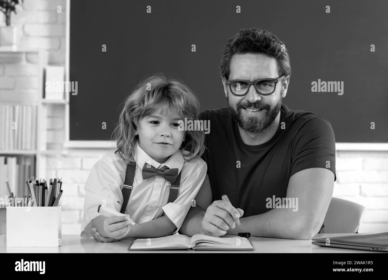 Retour à l'école. Père enseignant aidant un fils garçon en cours d'école. Banque D'Images