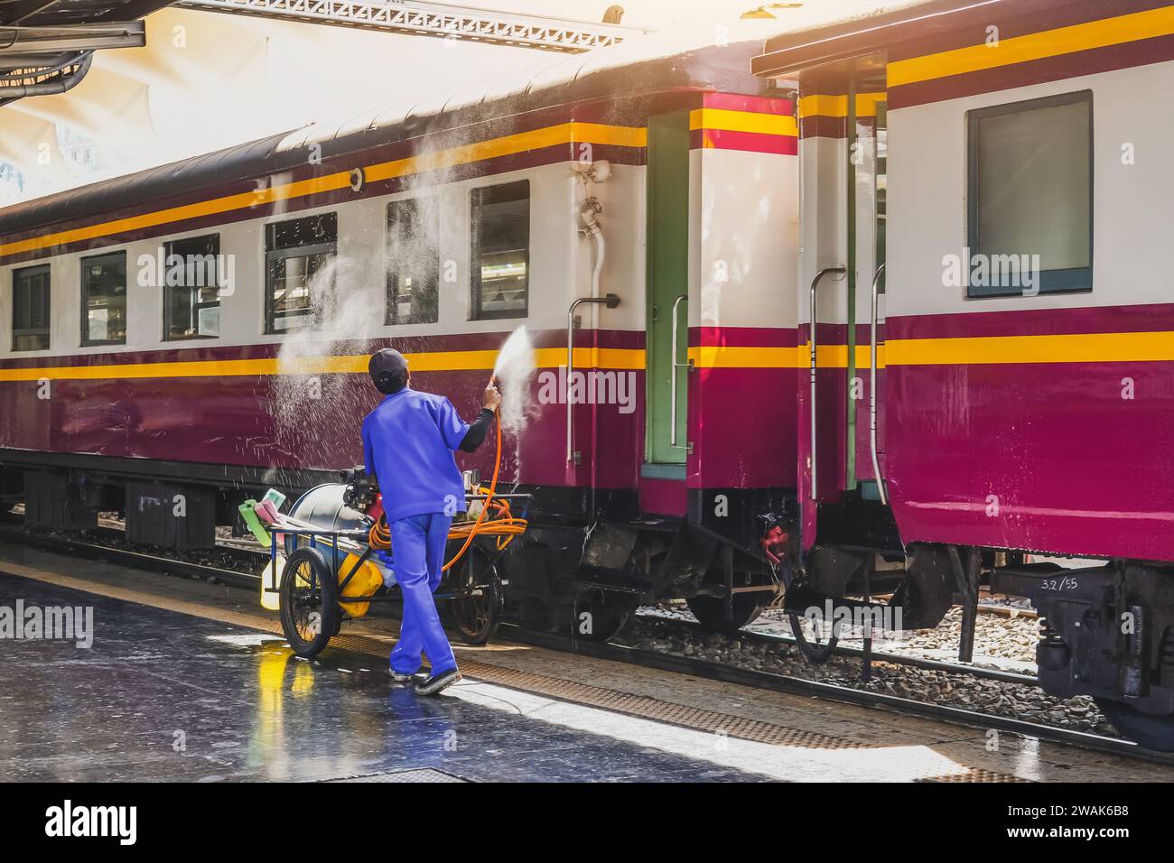 L'employé lave les voitures de voyageurs, le travailleur lave les voitures de train à la gare. Banque D'Images