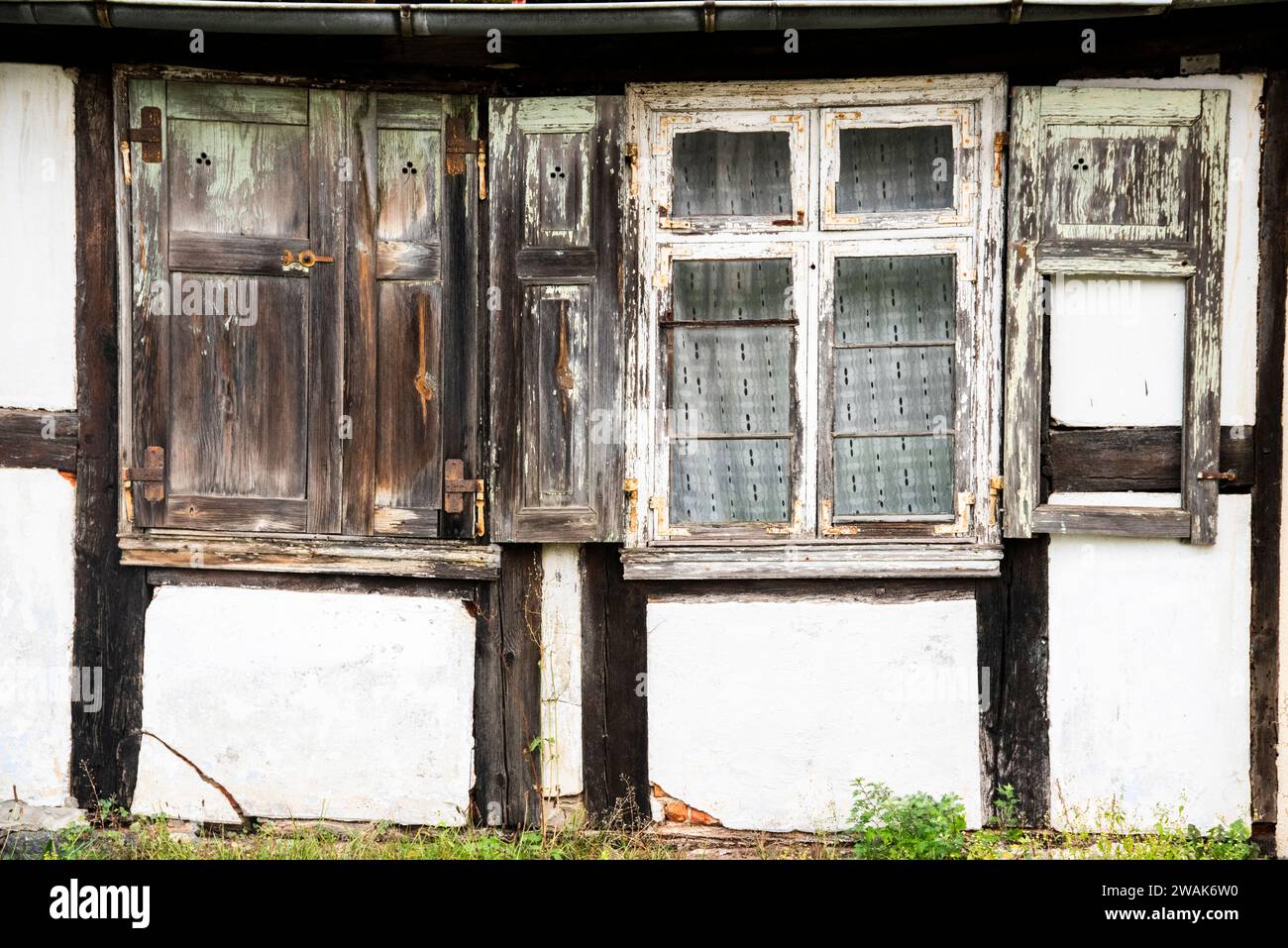 Vieilles fenêtres cassées et façade d'une maison de campagne à la campagne. Banque D'Images