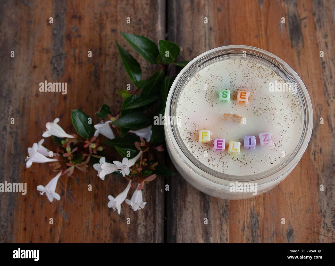 Bougie parfumée à la vanille et fleurs blanches sur une table en bois.Be message heureux Banque D'Images