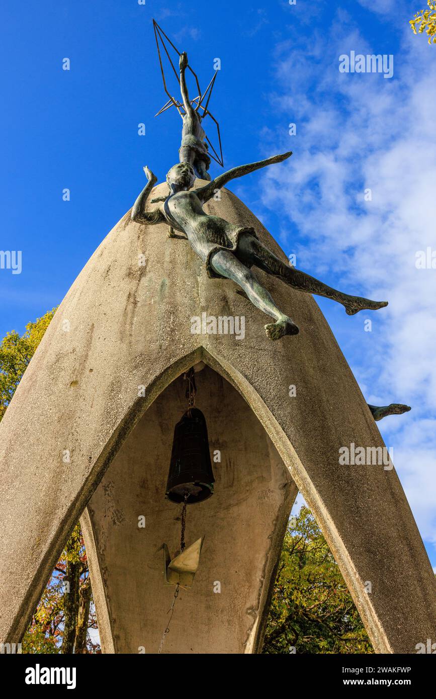 détail du mémorial de la paix des enfants à hiroshima montrant la moitié supérieure avec des statues d'enfants et la cloche de la paix avec un clanger en forme de grue en papier Banque D'Images
