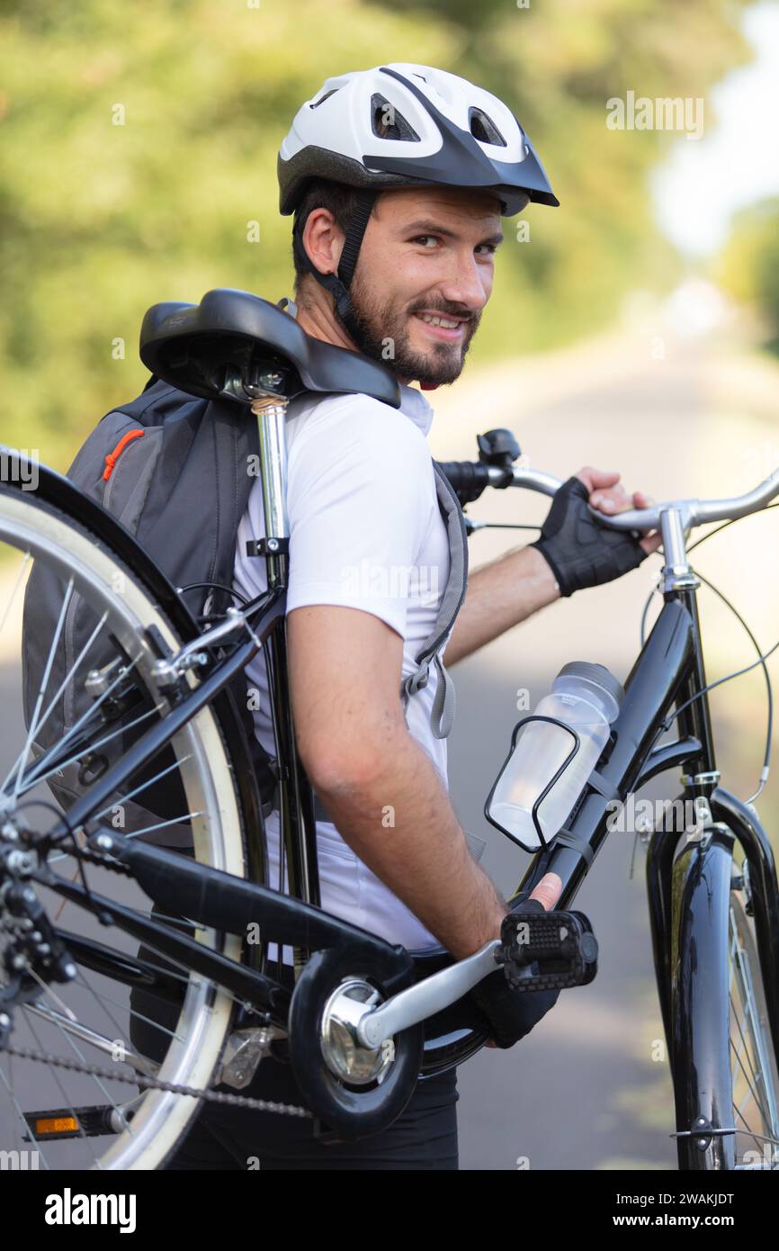 jeune beau sportif portant un vélo Banque D'Images