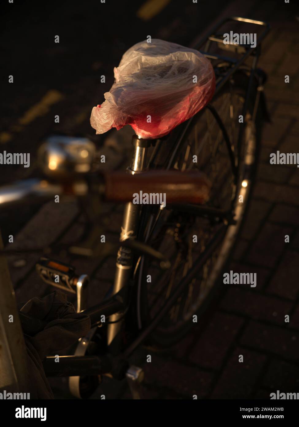 sac en plastique sur le siège de vélo le protégeant de se mouiller par la pluie Banque D'Images