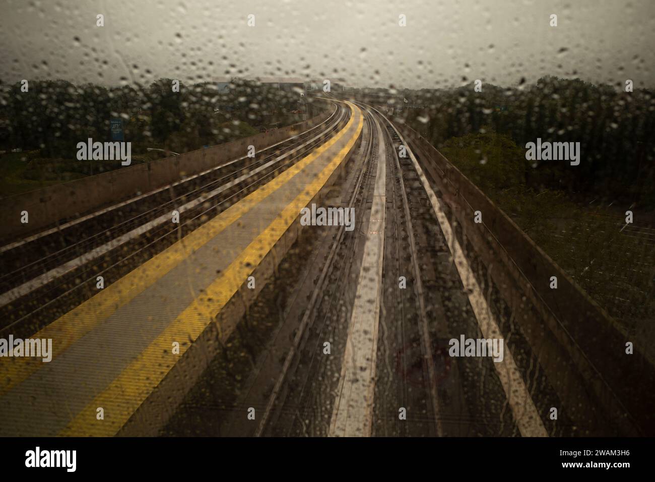 Vue depuis la fenêtre du train aérien approchant de l'aéroport JFK un jour de pluie Banque D'Images