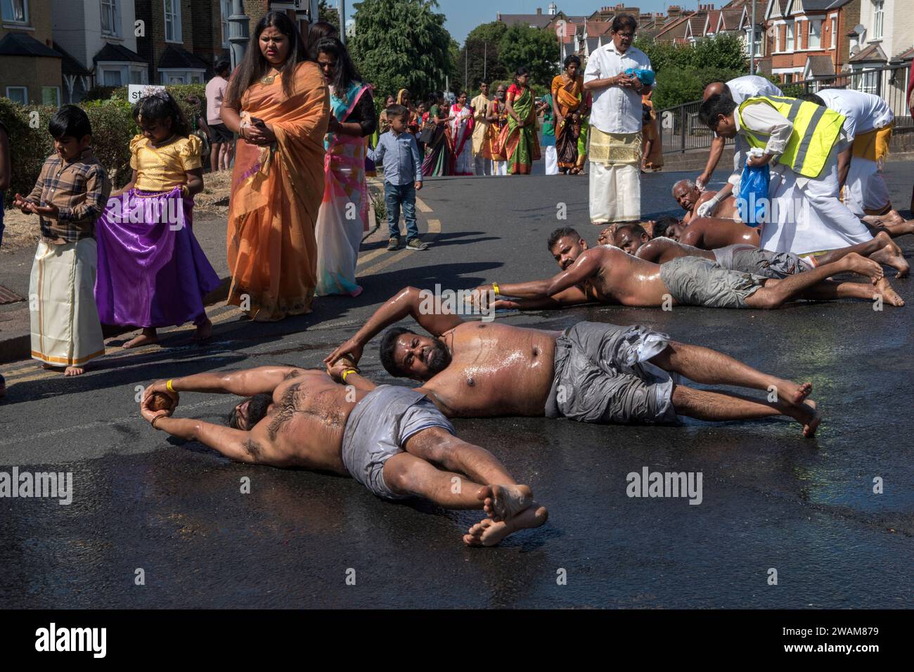 Festival britannique du chariot hindou au temple Shree Ghanapathy au sud de Wimbledon. Les membres de la communauté qui veulent remercier les dieux - Puri Jagannath, Balabhadra et Subhadra roulent nus à part d'une couenne et tiennent une noix de coco. Ils suivent les chars dans la procession comme un acte de dévotion. Wimbledon, Londres Angleterre 7 août 2022 Royaume-Uni HOMER SYKES Banque D'Images