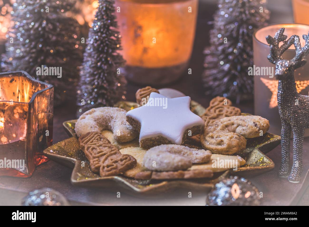 Biscuits de Noël sur une assiette en forme d'étoile avec décoration de noël et bougies Banque D'Images