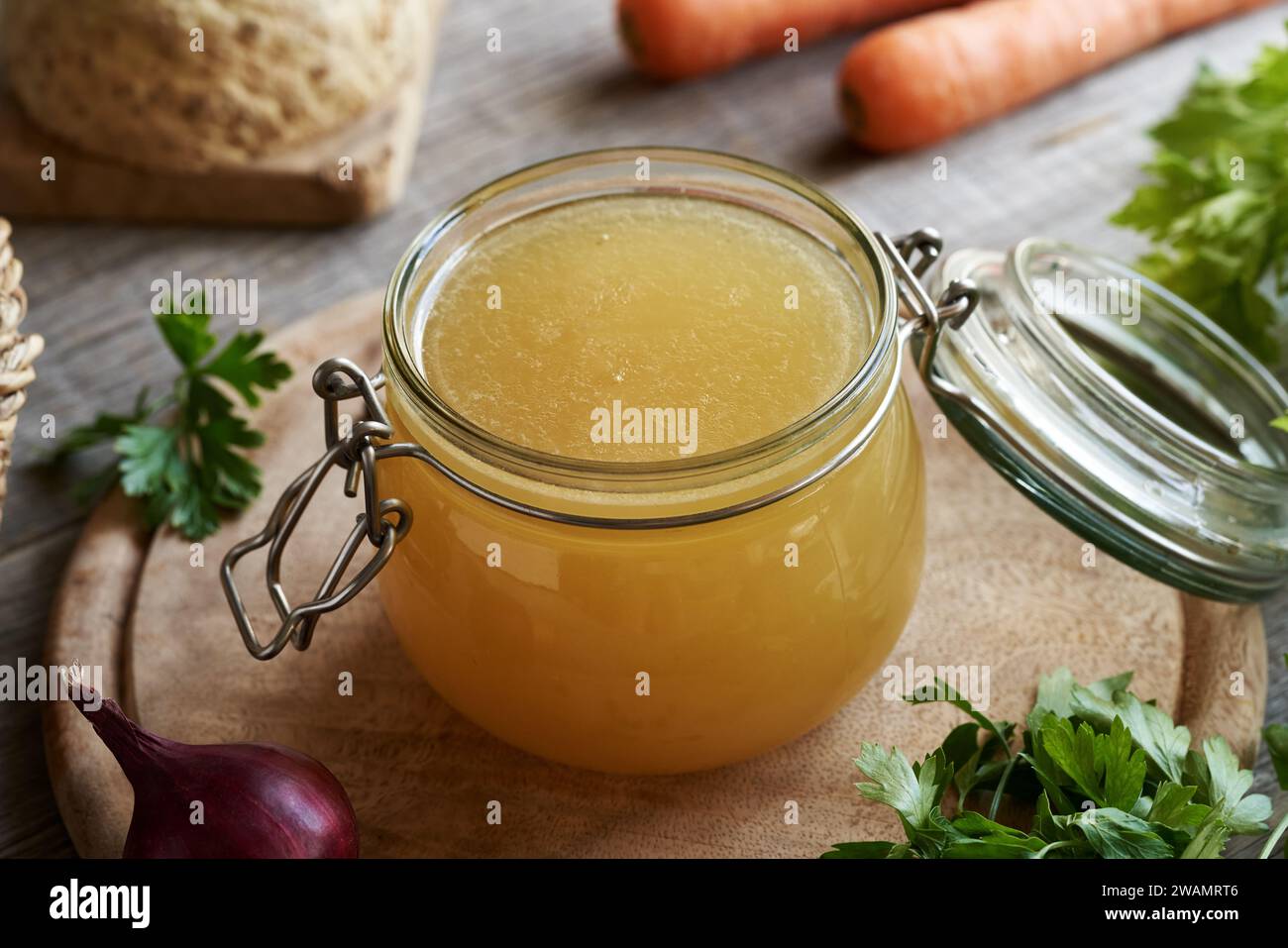 Bouillon d'os maison dans un bocal en verre, avec des légumes frais Banque D'Images