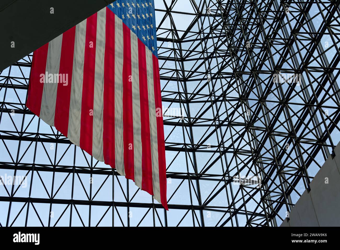 John F. Kennedy Presidential Library Boston, Massachusetts - Un drapeau américain géant est suspendu au plafond de verre de l'atrium de la Bibliothèque. Banque D'Images