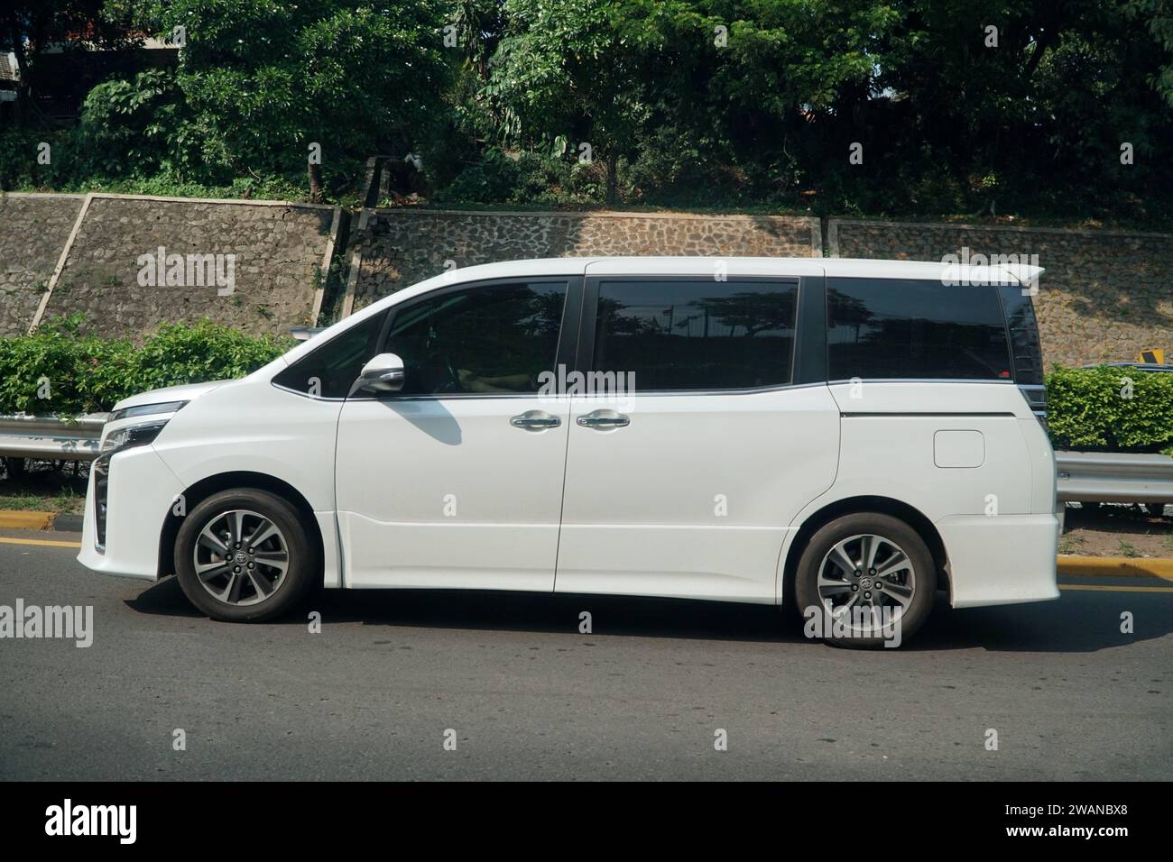 Titre véhicule polyvalent de luxe, blanc Toyota Voxy à Higway Jakarta Outer Ring Road, Jakarta, Indonésie. Banque D'Images