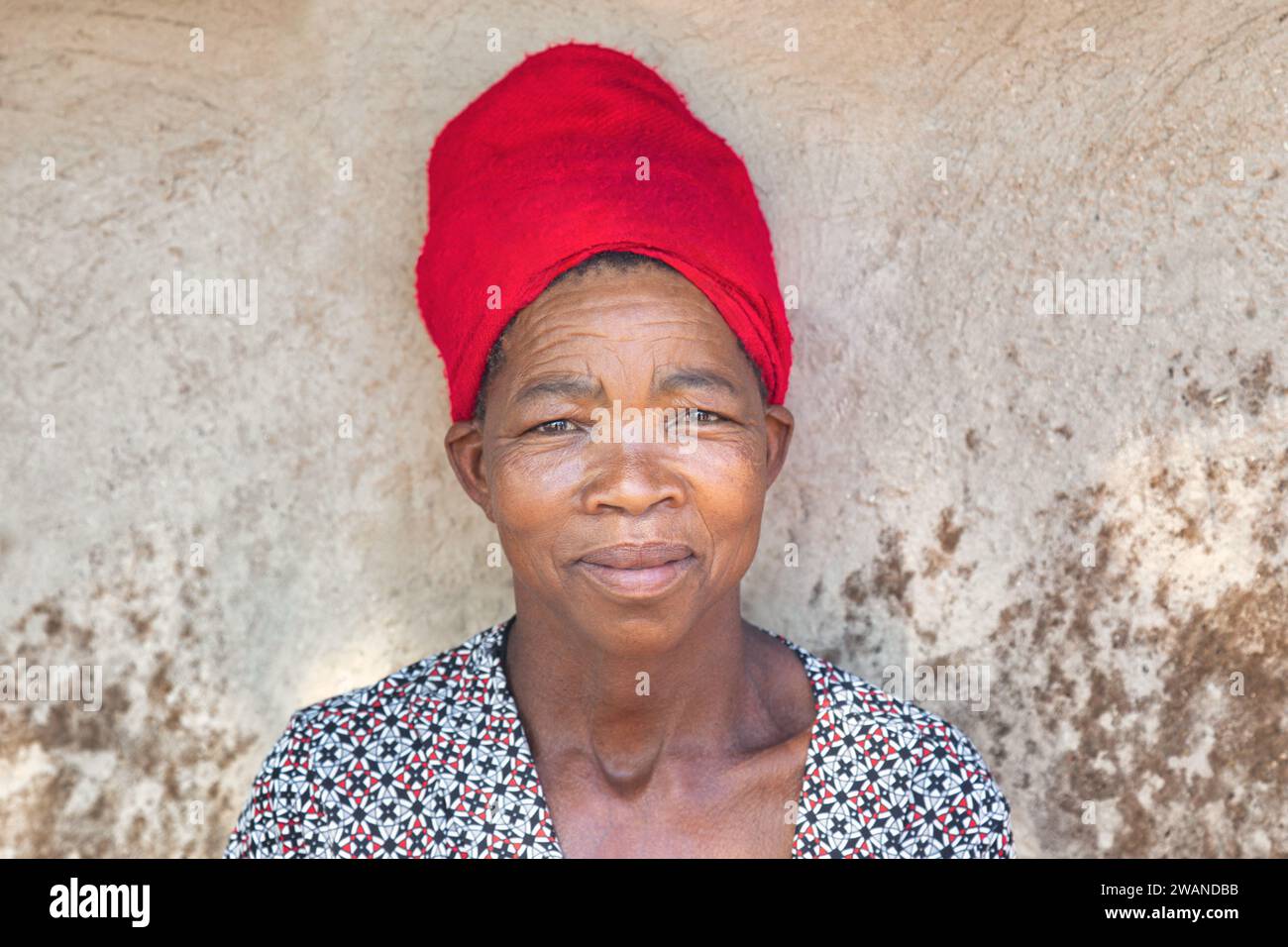 Portrait de femme africaine tête et épaules devant un mur de cabane de maison de boue, village au Botswana Banque D'Images