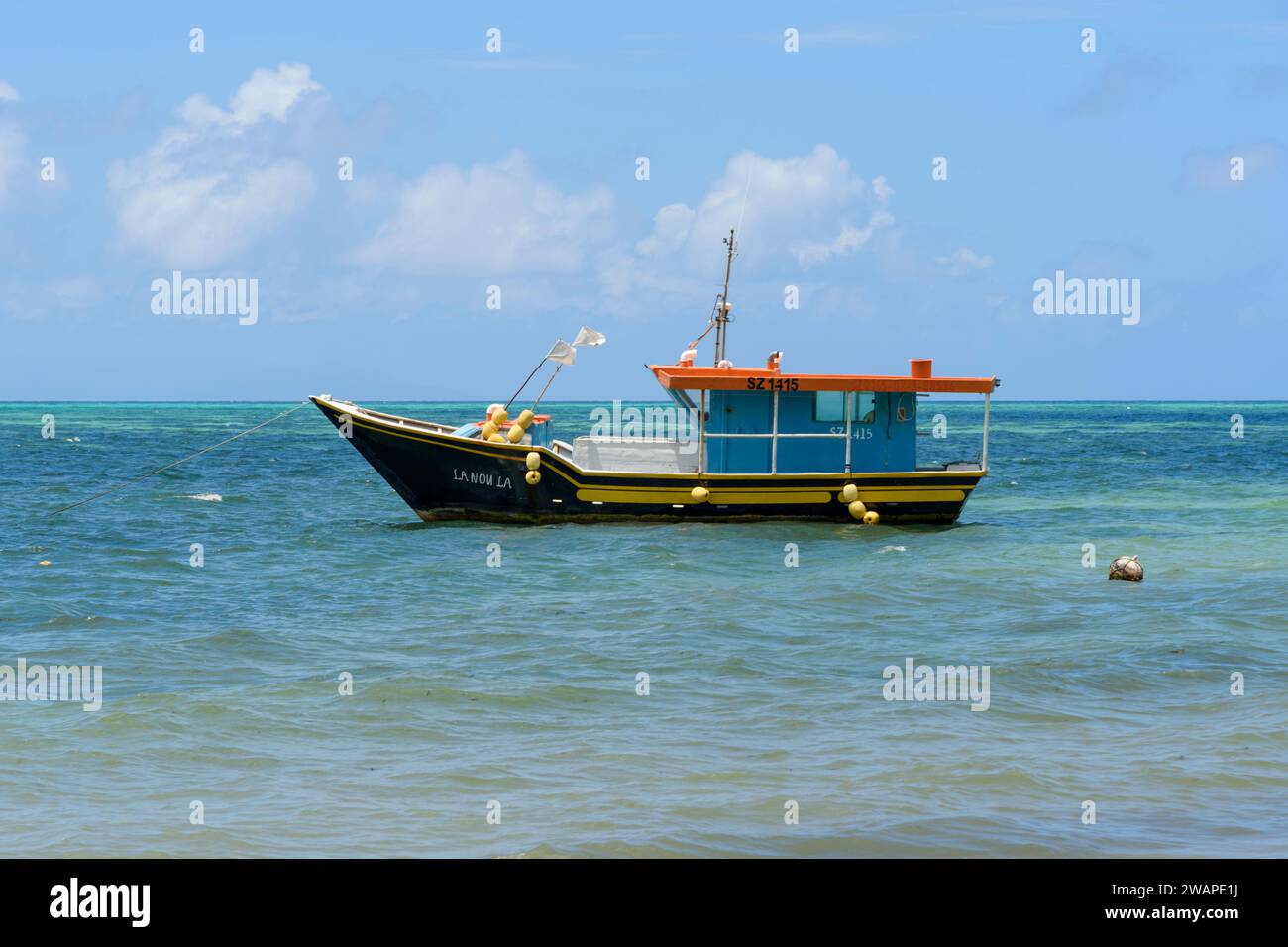 Bateaux de pêche amarrés au large de la plage de Grand Anse sur l'île de Praslin, Seychelles, océan Indien Banque D'Images
